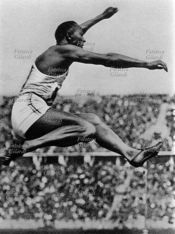 Jesse OWENS (12 settembre 1913 – 31 marzo 1980) atleta statunitense, immortalato in aria durante un salto in lungo; ha vinto l\