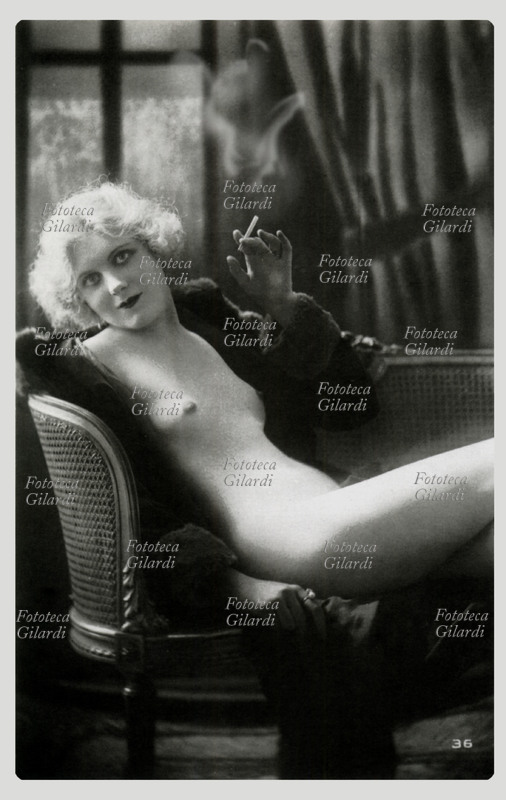 PIN UP in posa seducente mentre fuma una sigaretta. Cartolina postale, circa 1920