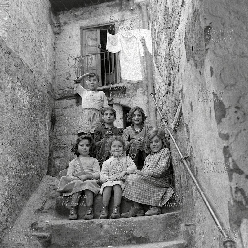 BAMBINI vivaci, in posa in cima ad una scala. Nonostante l\