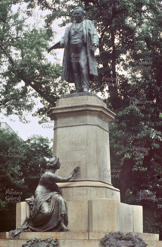 CAVOUR (Camillo Benso conte di, 1810-1861) monumento in bronzo, sito in Milano nella piazza omonima, realizzato nel 1865 da Odoardo Tabacchi e da Antonio Tantardini, autore della figura allegorica posta alla base della composizione rappresentante la Storia. Fotografia di Patrizia Piccini, 1993