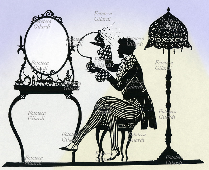 PROFUMO Giovane gentiluomo si profuma alla toilette. Silhouette 1920 circa, ispirata alla moda della metà del 1800.