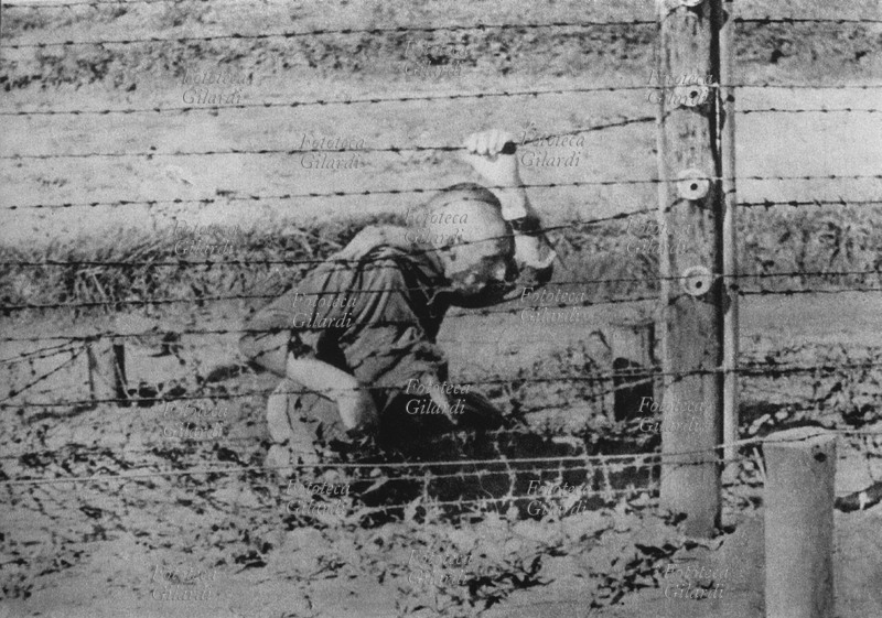 SHOAH prigioniero di un campo di concentramento non identificato in Polonia, si è suicidato con il filo spinato della recinzione, elettrificato ad alto voltaggio. Qualcuno della sorveglianza ha voluto documentare la scena. Fotografia spontanea, Polonia 1939-45.