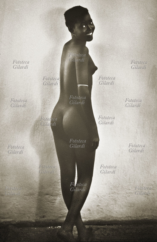 EROTISMO giovane africana ritratta di schiena, mentre si gira in una posa \
