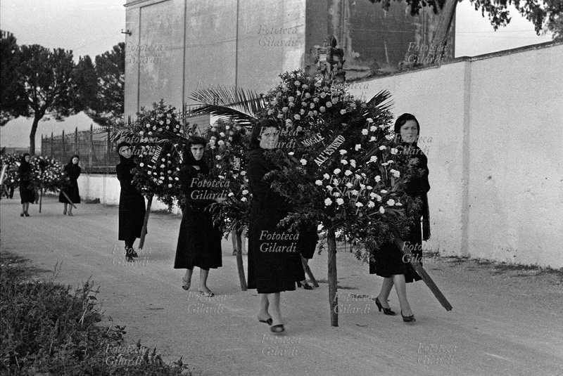 SAN DONACI 1957 Donne in corteo portano i pesanti supporti con le corone di fiori al funerale delle vittime dell\