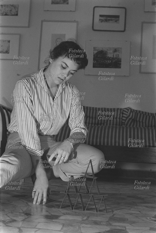 Valeria MORICONI (1931-2005) attrice italiana di cinema e teatro. Ritratta davanti ad un castello di carte, parte di un servizio fotografico realizzato da Ando Gilardi per il settimanale Vie Nuove, 1952 circa.