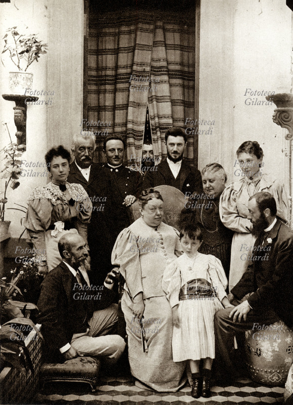 NAPOLEONIDI romani, fotogruppo a Palazzo Primoli. Da sin. (seduto) principe Placido Gabrielli figlio di Carlotta (figlia di Luciano Bonaparte), Maria Bonaparte con il padre, principe Napoleone Carlo, ten.Enrico Gotti (marito di Maria Bonaparte) conte Napoleone Parisani (figlio di una Gabrielli) si affaccia dalla tenda. Al centro la Marchesa Giulia di Roccagiovine, nata Bonaparte con la nipotina Matilde, il Conte Pompeo di Campello, Principessa Augusta Gabrielli, Marchesa Giacinta di Roccagiovine, Marchese Alberto di Roccagiovine. Italia, Roma 1893