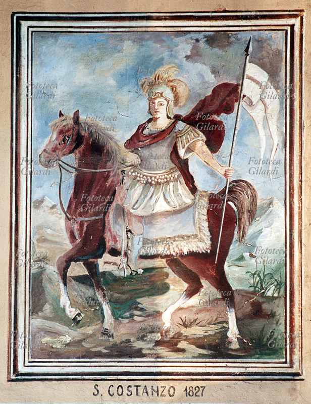 San COSTANZO (? - 286), militare romano, martire della Legione Tebea. Sfuggito alle decimazioni inflitte alla legione comandata da San Maurizio per essersi rifiutata di obbedire agli ordini di massacrare i cristiani del Vallese, si prodigò nella diffusione della religione cristiana, e finì decapitato sul Monte San Bernardo. Affresco, Sampeyre (Cuneo), frazione Calchesio, 1827. Fotografia di Elena Piccini, Italia 2002.