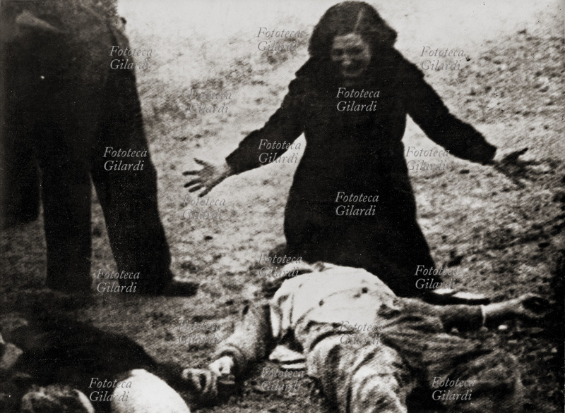 ITALIA 1944 Resistenza: fucilazione di un partigiano. La moglie grida la sua disperazione accanto al cadavere del marito giustiziato.