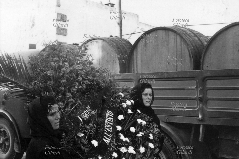 SAN DONACI Due donne trasportano una corona di fiori per una vittima dell\