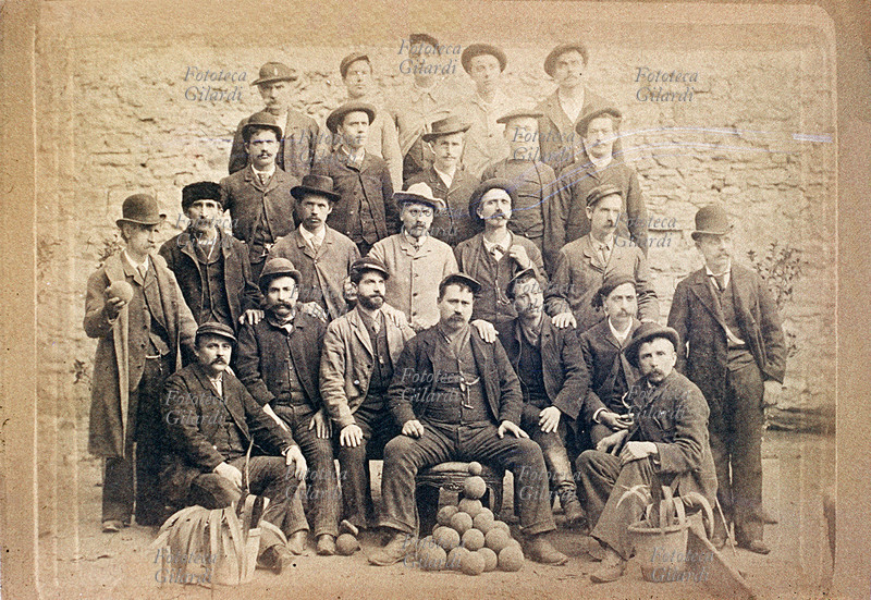 GIOCHI Splendida fotografia di una società bocciofila scattata da un fotografo ambulante. Si noti a sinistra il gobbo portafortuna. Italia, 1895 circa.