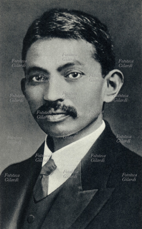 Mohandas GANDHI (2 ottobre 1869 – 30 gennaio 1948), politico, filosofo e avvocato indiano, in seguito ideatore e promotore della difesa nonviolenta dei diritti civili attraverso la disobbedienza civile di massa. Ritratto fotografico giovanissimo e vestito all\