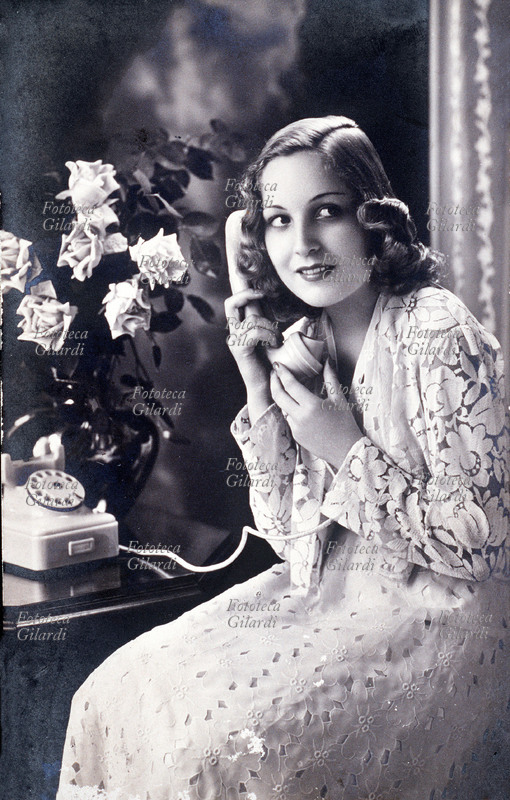 Young TELEPHONE woman speaks from the classic white telephone. Turin, 1942.