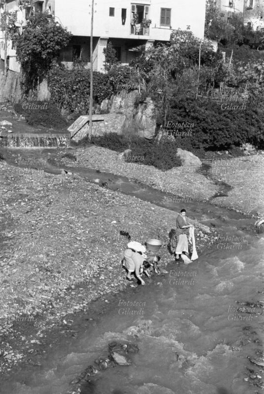 CASALINGHE in una giornata di sole, lavano i panni di famiglia al torrente. Fotografia di Ando Gilardi (1921 - 2012) #andogilardi, Nicastro 1955-58.