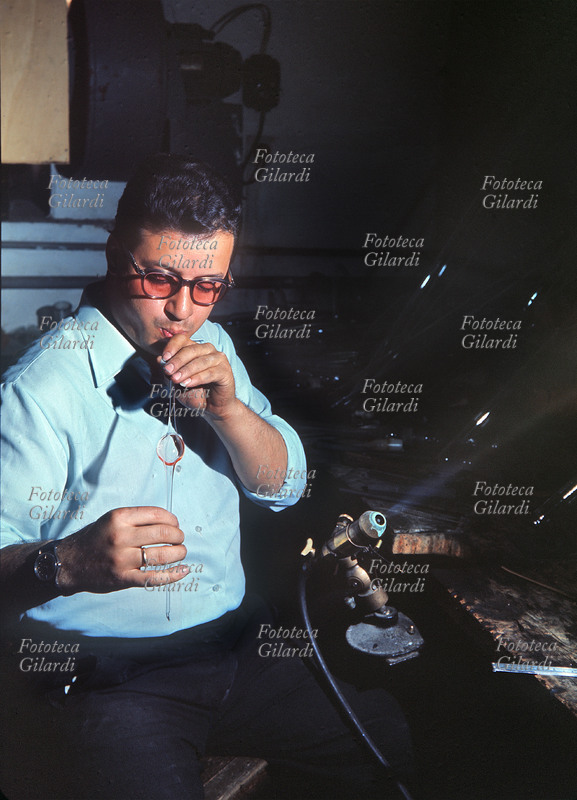 VETRO Una fase della lavorazione del vetro: la soffiatura. Fotografia di Ando Gilardi (1921 - 2012) #andogilardi, Italia 1960 circa.