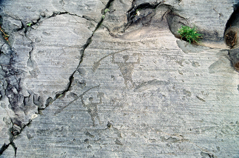 CAMUNI Two warriors with spears, petroglyphs on Permian sandstone of the Great Rock of Naquane. Rock Engravings National Park, age of iron / bronze - 5th / 1st millennium BC, site recognized by UNESCO as a "World Heritage Site" in 1979. Photograph by Elena Piccini, Capo di Ponte (BS), Naquane, Valle Camonica, 1989.
