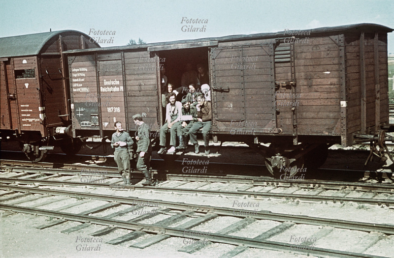 II GUERRA MONDIALE Tradotta in transito in una stazione polacca, con i reduci della spedizione italiana sul fronte russo. Rara testimonianza fotografica a colori di Gianfranco Ucelli (Divisione Julia, Battaglione Aquila, 3° Art. Alpini), anch\