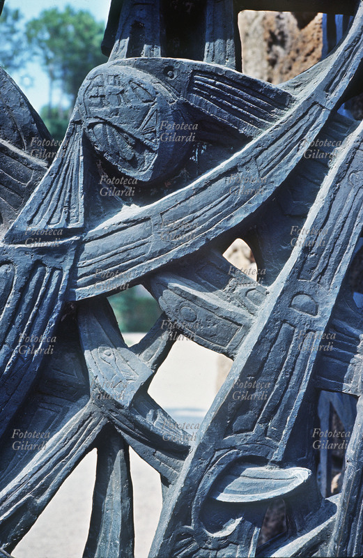 FOSSE ARDEATINE dettaglio di uno dei cancelli bronzei del mausoleo delle Fosse Ardeatine, modellati dallo scultore Mirko Basaldella (1910 - 1969) realizzati nel 1950-51. Concepito inizialmente come bassorilievo figurato è stato infine risolto in un ossessivo riflusso di ritmi plastici molto drammatici. Fotografia di Ando Gilardi (1921 - 2012) #andogilardi, Roma 1962.