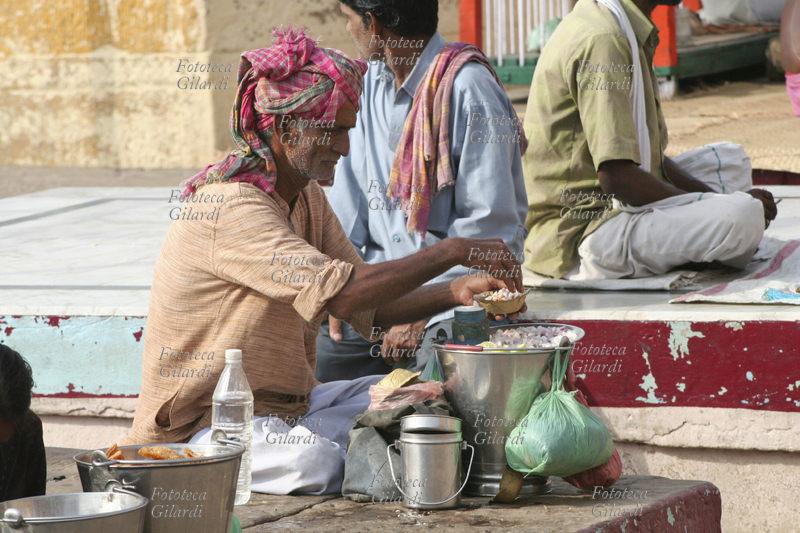 INDIA Vicino al Mir ghat, un anziano prepara il suo pasto seduto sulla scalinata che porta al Gange. Fotografia di Raffaella Milandri. India, Varanasi / Benares maggio 2007