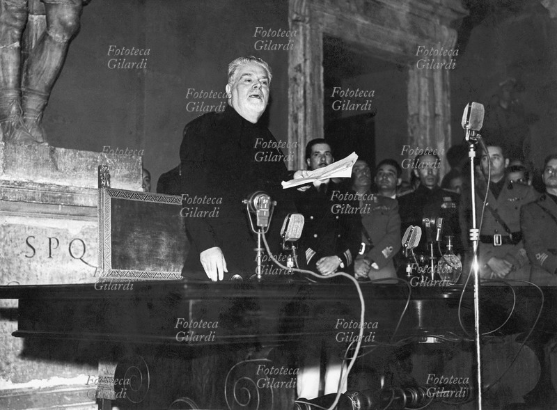 Giovanni GENTILE (1875-1944) il senatore parla agli italiani nella Sala Giulio Cesare in Campidoglio. Professore a Palermo, Pisa e Roma, fu ministro della Pubblica Istruzione (1922-24); celebre la sua riforma della scuola che condusse in chiave anti-illuministica e anti-positivistica. Fotografia, Roma 1943.