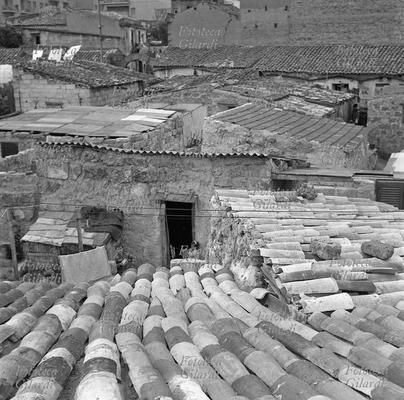PALERMO the roofs of the popular Scalilla courtyard; in the center of the image three children play in front of a door. Photograph by Ando Gilardi (1921 - 2012) #andogilardi from ample service, Palermo, 1957.