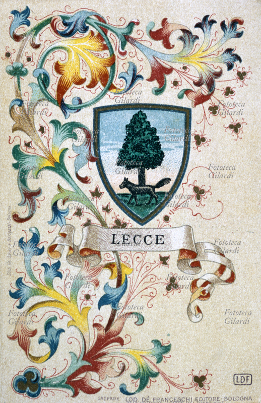 LECCE stemma della città. Al naturale, alla lupa passante di nero, attraversante il fusto di un albero di leccio di verde in palo, sorgente dalla campagna. Cromolitografia, Stabilimento litografico Sauer & Barigazzi, Bologna. Gaspare Lod. Dè Franceschi Editore, Bologna 1900.