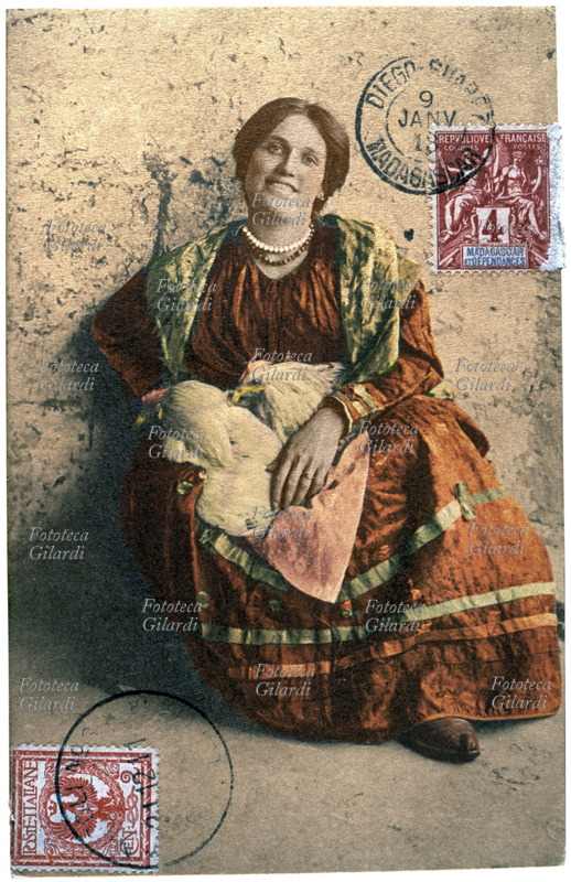 NAPOLI venditrice di polli vivi. Cartolina postale fotografica dalla serie "Tipi e Costumi napoletani" con doppia affrancatura: italiana da due centesimi di Lira con annullo del 1911 e malgascia (francese coloniale), da 4 centesimi di Franco con annullo del 1913. Italia 1913