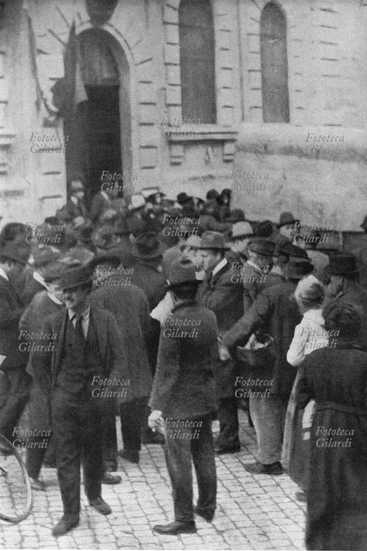 ELEZIONI POLITICHE Roma, gli elettori si recano alle urne. Per la maggior parte di loro sarà il primo voto, grazie alla riforma elettorale (n. 1401 del 15 agosto 1919) che prevede, oltre al sistema proporzionale, anche il suffragio maschile indipendente dal censo. Sui manifesti compaiono per la prima volta lo scudo crociato del Partito Popolare di Don Luigi Sturzo e i Fasci di Combattimento di Benito Mussolini, che non si aggiudicheranno nemmeno un seggio in queste elezioni politiche del 16 novembre 1919.