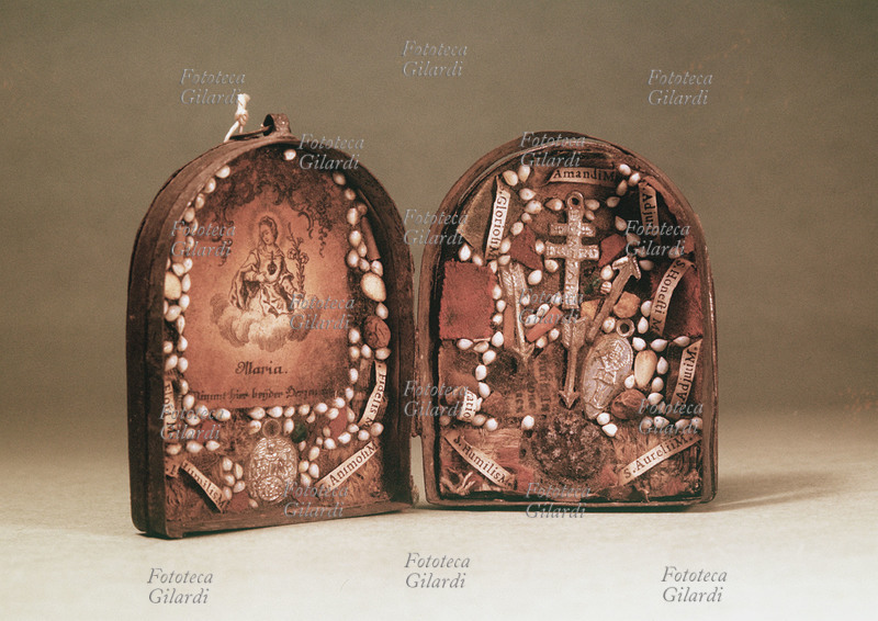 AMULETI piccolo tabernacolo popolare pieghevole del XVIII secolo, contenente vari amuleti legati a vari nomi di Santi e alla Vergine Maria, efficaci per allontanare il malocchio e le fatture. Fotografia di Ando Gilardi (1921 - 2012) #andogilardi, Italia 1957.