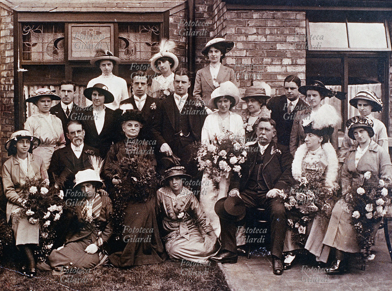 MODA. Fotografia di un bellissimo gruppo borghese, riunito in occasione di una cerimonia nuziale. Si può notare un assortimento di cappelli femminili in voga in quegli anni. Nel lato sinistro, sullo sfondo, una vetrata un stile Liberty. Italia anni 1910-19.
