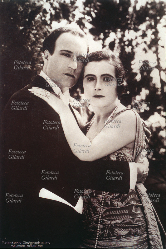 Francesca Bertini (1892) and Jean ANGELO, cinematographic actors. Portraits in an embrace in outside, a background of trees. The reputation of the actress, beautiful and fatal woman gave origin to the divismo in Italy. Photography distributed from Sélections Cinematographiques, Maurice Rouhrier, 1918 approximately.