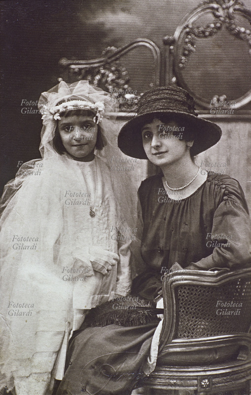 PRIMA COMUNIONE bambina comunicanda posa insieme alla madre per una fotografia ricordo. Italia 1900 circa.