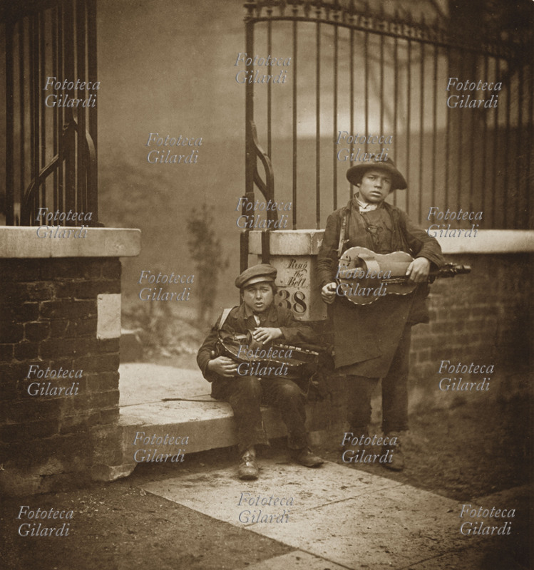 MUSICA 1800 Giovani suonatori ambulanti in Porchester Terrace. Questi giovani musicisti, poco più che bambini, erano italiani emigrati al Nord per sfuggire alla miseria. Spesso putroppo erano sfruttati da connazionali che gestivano gruppi di bambini mendicanti. Il loro strumento, la ghironda è dal XIII secolo un classico dei suonatori girovaghi in tutta Europa. Porchester Terrace, Londra 1860 circa