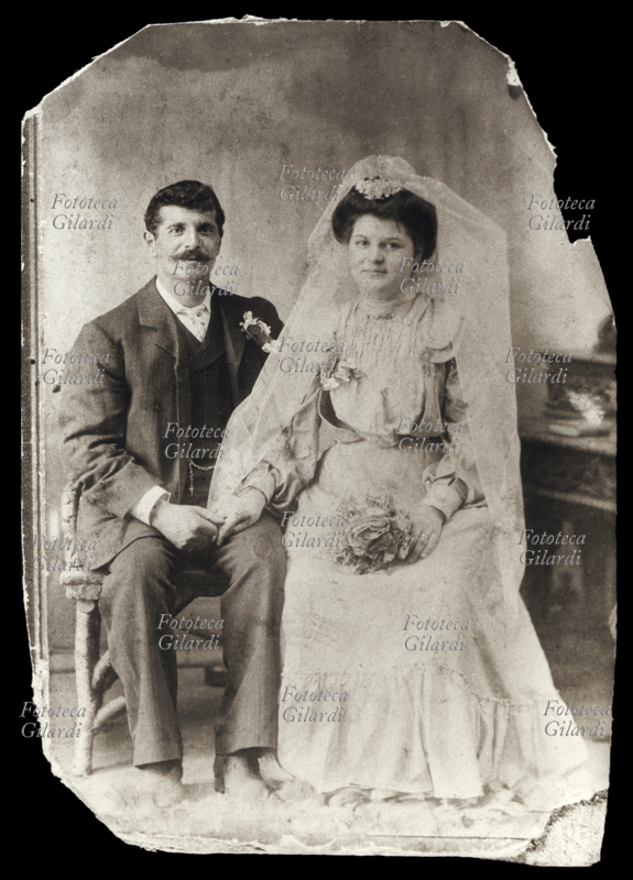 MATRIMONIO Coppia di sposi in una fotografia ricordo, posano seduti, tenendosi una mano. Italia 1890 circa
