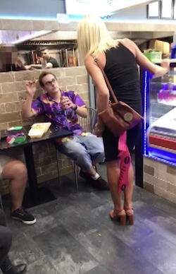 PIC FROM MERCURY PRESS (PICTURED: THE WOMAN DARES LEWIS CALEY TO THROW THE CHIP AT HER IN A TAKE AWAY IN CLACTON-ON-SEA IN ESSEX) This is the moment a foul-mouthed blonde lady launched herself at a drunken reveller in a shocking takeaway brawl - because he suggested she was in her 60s and threw a chip in her face. Lewis Caley and his friends were getting food from the Quality Diner takeaway in Clacton-on-Sea, Essex, after celebrating his 20th birthday. However an argument ensued when cocky Lewis asked one of the women - estimated to be in her 30s - how old she was and then jokingly suggested she was in her 60s. Footage shows the blonde brand jolly engineer Lewis a c**t and then repeatedly try to snatch his food from him as he sits eating. SEE MERCURY COPY