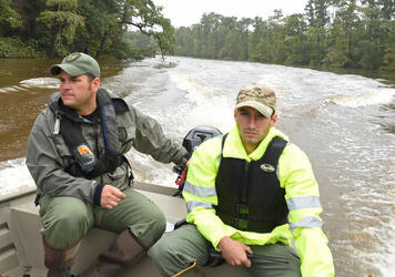 August 31, 2017 - Calcasieu Parish, Louisiana, United States: Calcasieu Parish Sheriff's Deputies, Marine Division,Sr. Cpl. Mark Rosteet, left and Sgt. Brandon Miller, right, take their boat a flooded Calcasieu River to rescue a man and woman from their flooded homes Wednesday. Rain from Hurricane Harvey caused flooding on almost all tributaries and rivers in the Parish. (Patrick Dennis/The Advocate / Polaris)