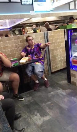 PIC FROM MERCURY PRESS (PICTURED: LEWIS CALEY ATTEMPTING TO SHARE A JOKE WITH THE BLONDE WOMAN IN A TAKE AWAY IN CLACTON-ON-SEA IN ESSEX) This is the moment a foul-mouthed blonde lady launched herself at a drunken reveller in a shocking takeaway brawl - because he suggested she was in her 60s and threw a chip in her face. Lewis Caley and his friends were getting food from the Quality Diner takeaway in Clacton-on-Sea, Essex, after celebrating his 20th birthday. However an argument ensued when cocky Lewis asked one of the women - estimated to be in her 30s - how old she was and then jokingly suggested she was in her 60s. Footage shows the blonde brand jolly engineer Lewis a c**t and then repeatedly try to snatch his food from him as he sits eating. SEE MERCURY COPY