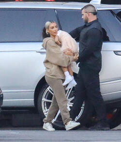 Kim Kardashian carrying a sleepy princess Nori