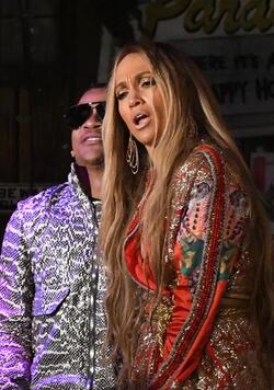 Jennifer Lopez wears a low cut red wrap dress with shimmering gold sequins as she is seen filming a music video