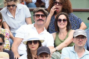 Jean Dujardin and his wife Nathalie Pechalat keep each other moisturised at the French Tennis Open at Roland Garros