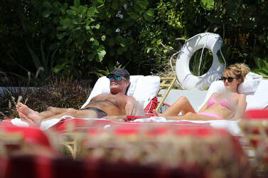 Baywatch actor David Hasselhoff wears tiny black swim trunks as he relaxes with his bikini clad finance Hayley Roberts by the pool in Miami.