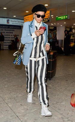 Rita Ora in a Striped Track Suit at Heathrow Airport