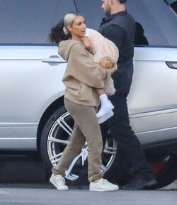 Kim Kardashian carrying a sleepy princess Nori