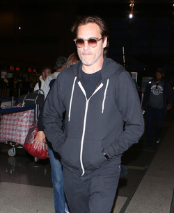 The enigmatic Joaquin Phoenix sports a scruffy beard zip up hoodie and shades as he spends National Brother s Day catching a flight with his lovely sister Summer.