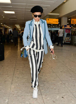Rita Ora in a Striped Track Suit at Heathrow Airport