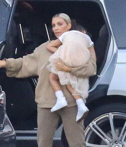 Kim Kardashian carrying a sleepy princess Nori