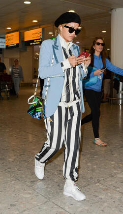 Rita Ora in a Striped Track Suit at Heathrow Airport