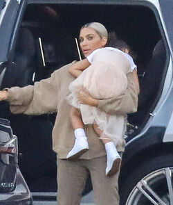 Kim Kardashian carrying a sleepy princess Nori