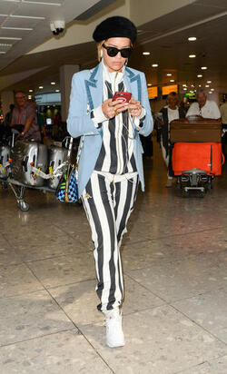 Rita Ora in a Striped Track Suit at Heathrow Airport