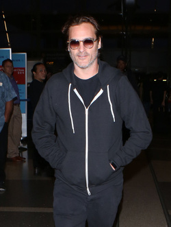 The enigmatic Joaquin Phoenix sports a scruffy beard zip up hoodie and shades as he spends National Brother s Day catching a flight with his lovely sister Summer.
