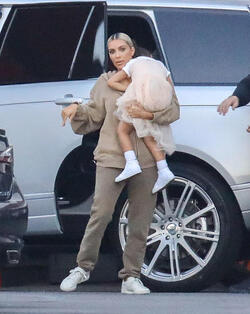 Kim Kardashian carrying a sleepy princess Nori